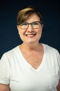 Smiling woman with glasses in a white shirt
