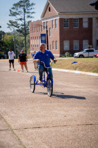 Smiling man in a blue shirt rides