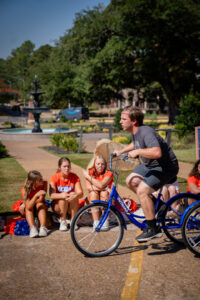 Man on a blue tricycle outdoors,