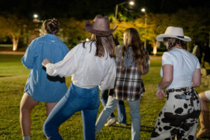 Four women from behind on grass