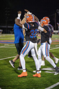 Football players in black and orange uniforms with