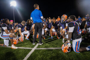 Football coach addresses his team of players