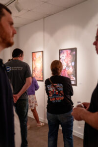 People viewing colorful paintings in