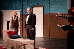 Three actors on a stage set