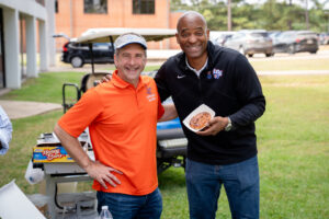 Two smiling men at an outdoor college event