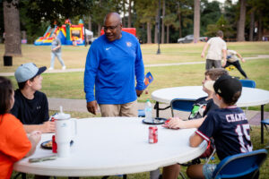 Man in blue shirt talks to kids