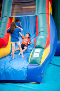 Kids playing on a vibrant inflatable slide.