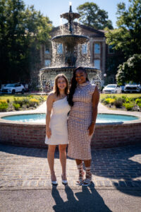 Two smiling women pose in front of a