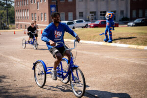 Man in LCU Football shirt rides a