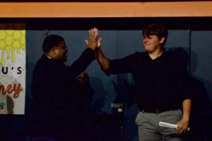 Two smiling young men high-five,