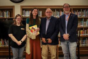Four people, including an author holding