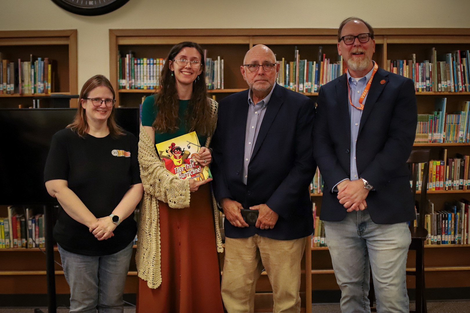 Four people, including an author holding