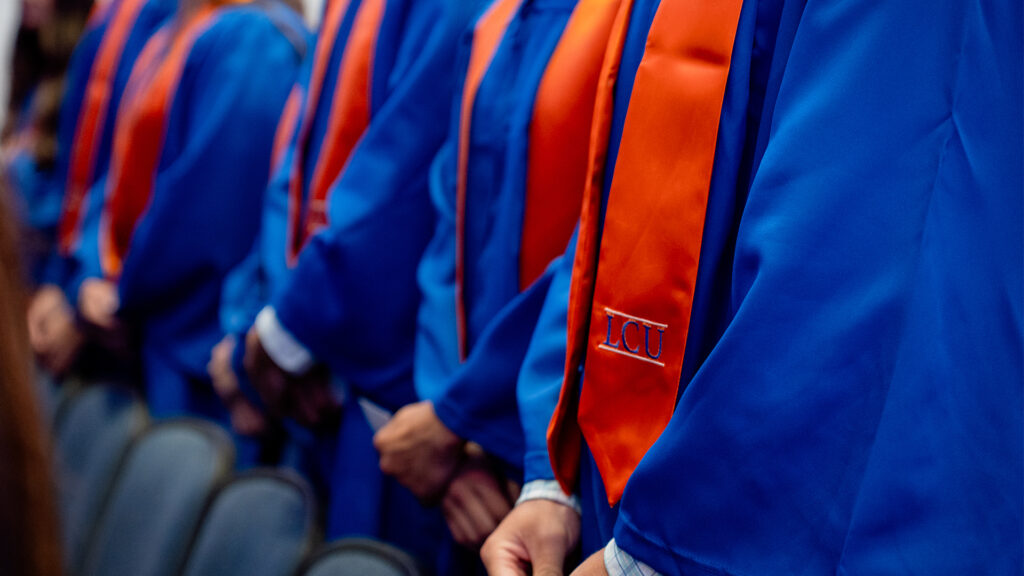 Graduates in regalia in Guinn Auditorium.
