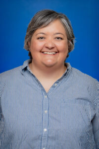 Smiling woman with gray hair in a blue