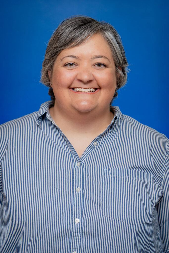 Smiling woman with gray hair in a blue