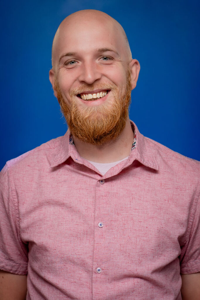Smiling bald man with a red beard in