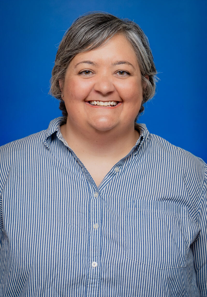 Smiling woman with gray hair in a blue